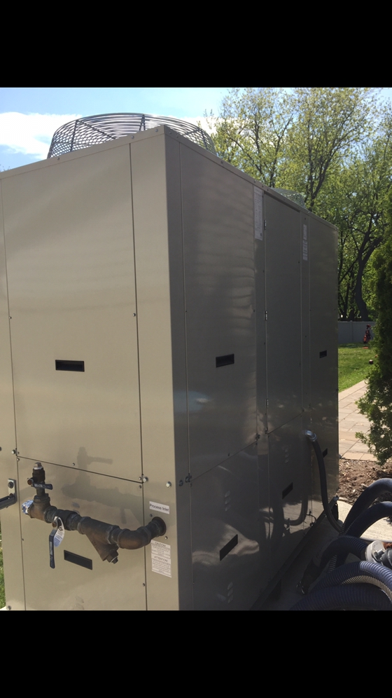 Side view of an ice rink chiller for a  for a residential portable refrigerated outdoor ice hockey rink